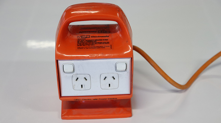 The image shows an orange and white outlet box, which has four outlets..