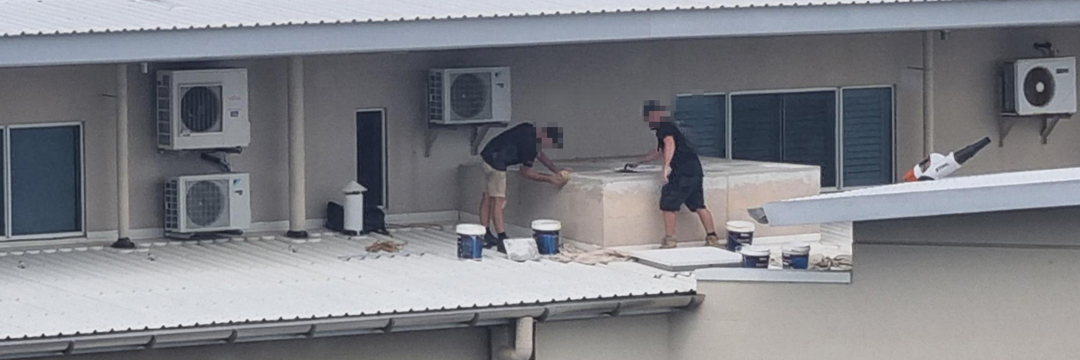 The image shows a supervisor and worker on a ten storey roof with no fall protection.