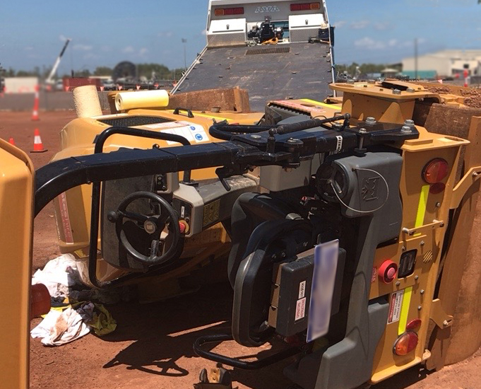 The image shows the 2.7 tonne compactor in situ after toppling. The tilt tray truck can be seen in the background.