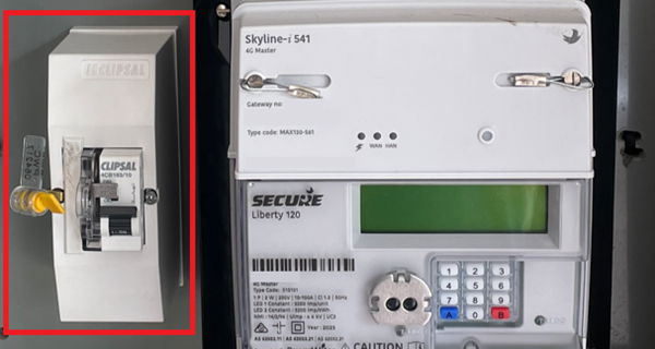 The image shows the inside of a meter box fitted with a new electronic meter. The left of the image shows a circuit breaker used as a meter isolator.