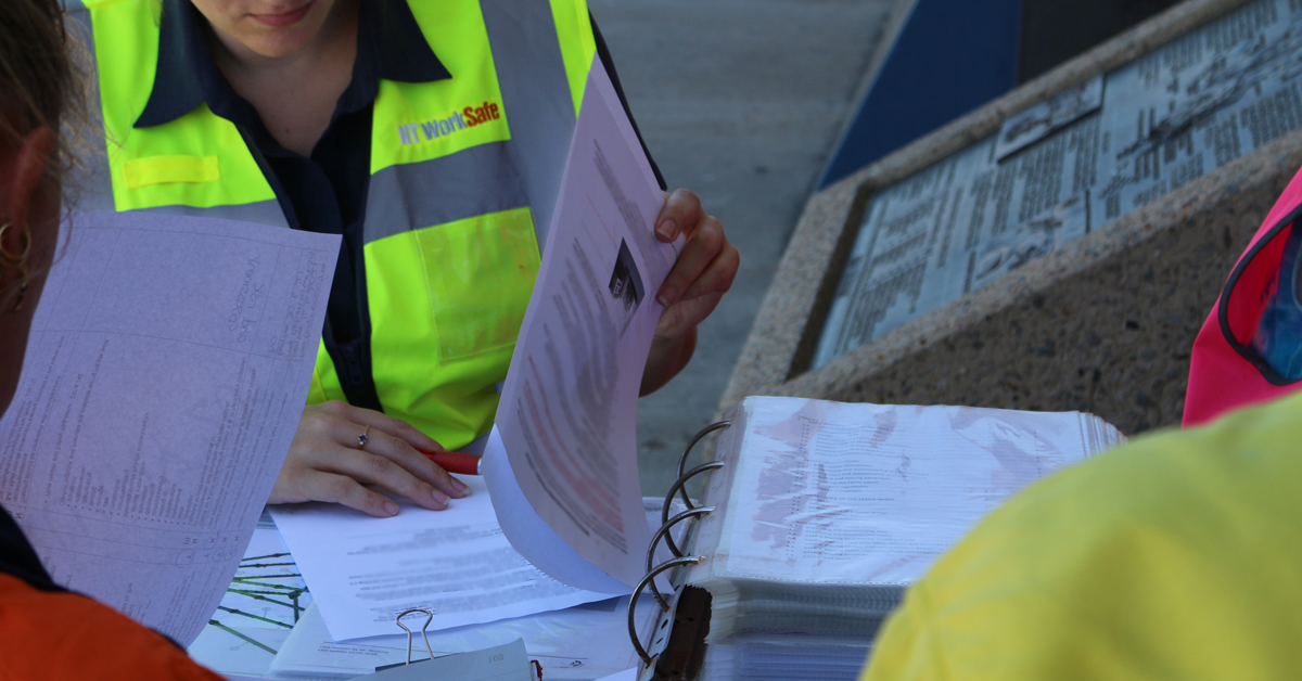 Image is a close up shot of Inspectors auditing the Ferris Wheel logbooks