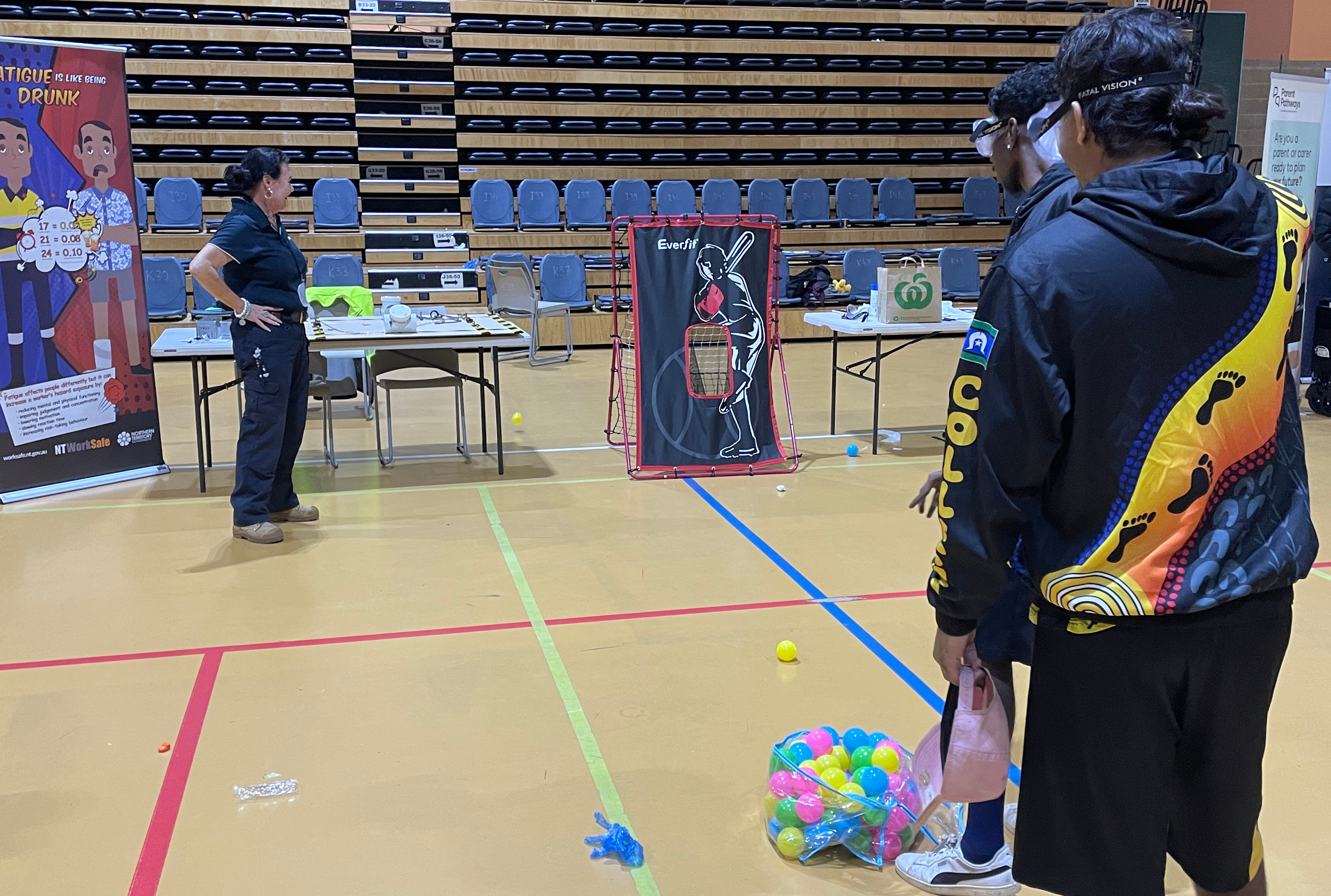 WorkSafe inspector engages with students participating in interactive activities at the NT WorkSafe stall during the Central Careers Expo 2025