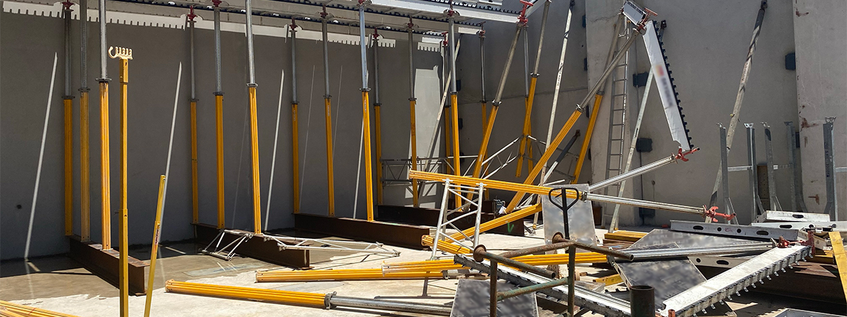 The incident scene where 15 metres of formwork collapsed. The image shows the aftermath of the formwork collapse with formwork struts and other material jumbled on the ground.