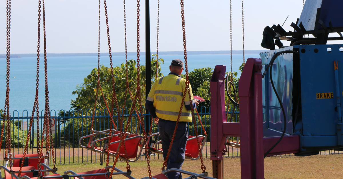 The image shows an Inspector checking the chair swings set up at the Glenti.