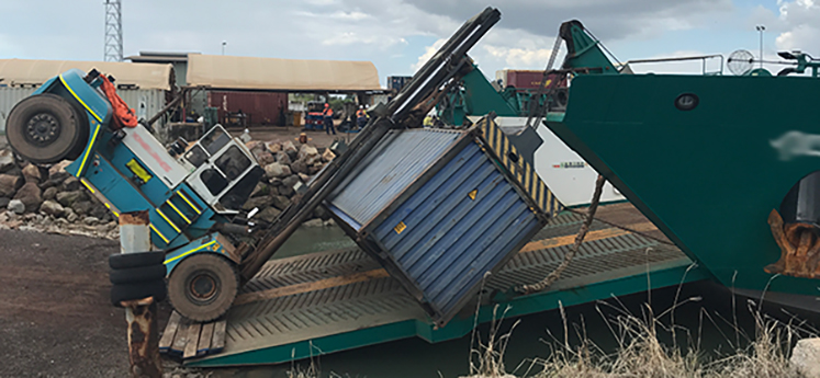 Incident 2: Travelling with a raised load weighing above the forklifts rated capacity increases the risk of tipping. The image shows a 37 tonne forklift carrying a shipping container, tipped forward onto the bow ramp of a vessel.