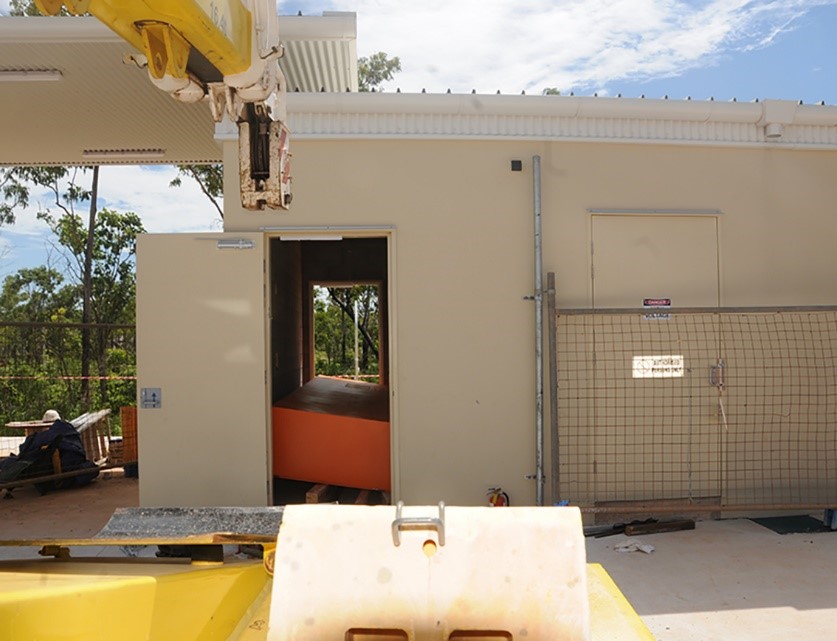A crane was needed to get the switchboard through the door. Image taken outside of the switchroom, showing the toppled switchboard through the open door.