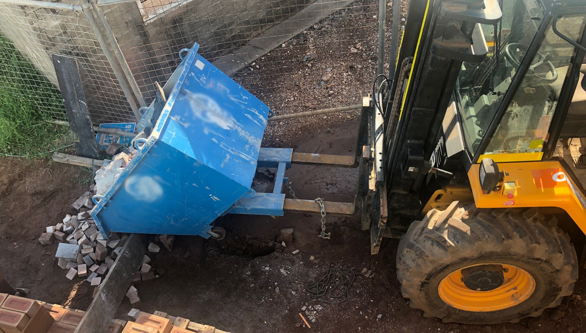 Image 1: The forklift tines were not fully inserted into the bin pockets. The image of the forklift shows the tines were not fully inserted into the bin pockets.